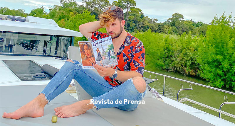 Chico joven leyendo una revista a bordo de un barco Le Boat